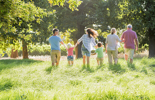 Generationen gehen nebeneinander über die Wiese. | © flairimages - Fotolia.com